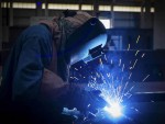 worker with protective mask welding metal