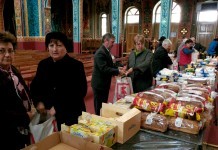100 pachete cu alimente şi îmbrăcăminte pentru familiile sărace