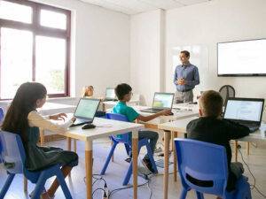 Confident teacher explaining lesson to pupils
